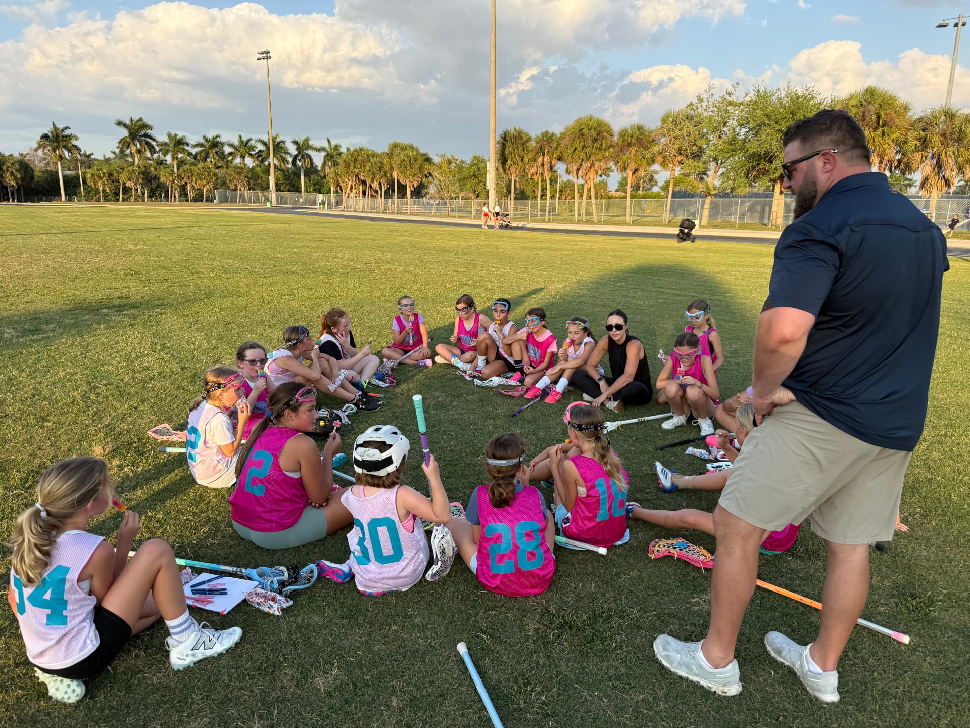 SWFL Storm players and coaches gathered in a circle on the field