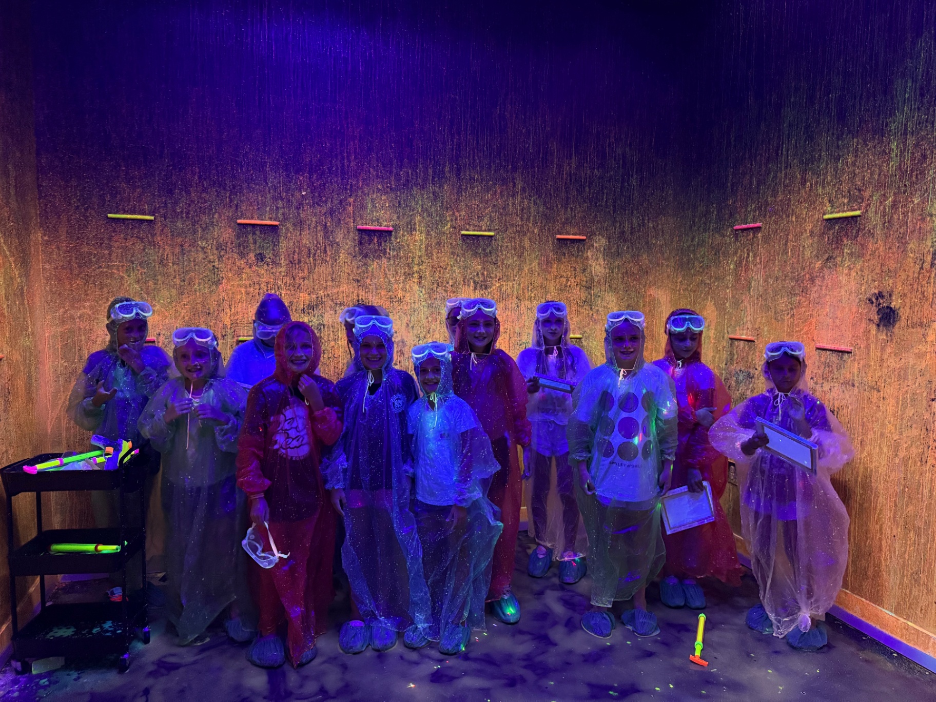 Storm players in ponchos and goggles at a glow-in-the-dark paintball party